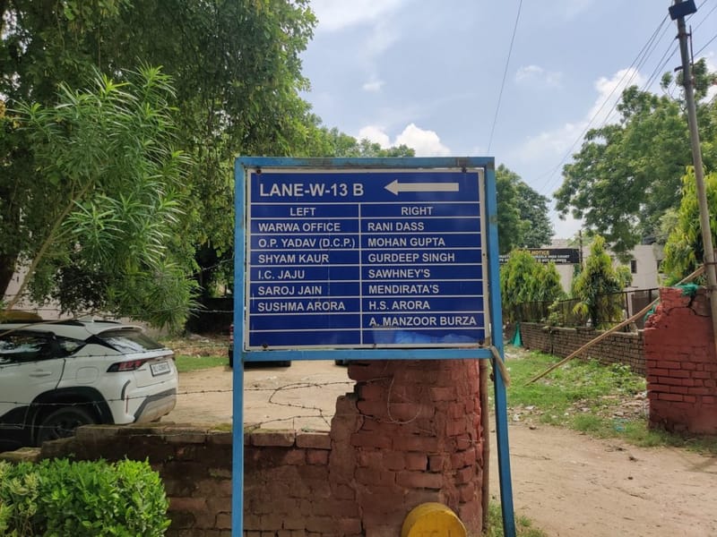 सैनिक फार्म में एक साइनबोर्ड. यह इलाका 1960 के दशक के आखिर में युद्ध विधवाओं और रिटायर्ड रक्षा कर्मियों के लिए एक कोऑपरेटिव सोसाइटी के तौर पर शुरू हुआ था | फोटो: अलमिना खातून/दिप्रिंट