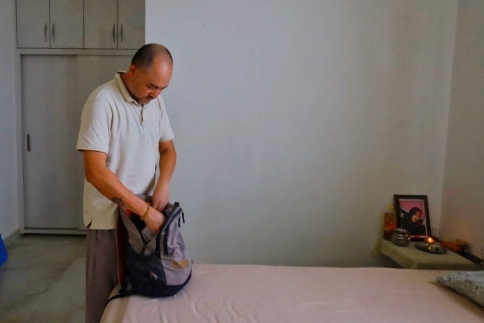 Rajesh Mall Thapa takes out books and copies from Riya’s bag | Photo: Manisha Mondal | ThePrint