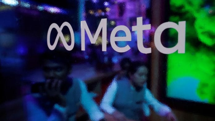 People are seen behind a logo of Meta Platforms, during a conference in Mumbai, India, 20 September, 2023. Francis Mascarenhas/Reuters