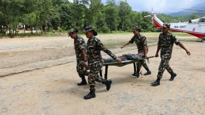 Nepali army soldiers move a survivor on a stretcher following flash floods and a mudslide near the Nepal-Tibet border in Nepal, in this handout image obtained on August 27, 2026. Nepali Army/Handout via REUTERS