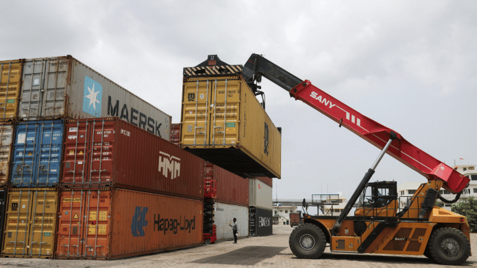 A mobile crane carries a container to stack at Thar Dry Port in Sanand in the western state of Gujarat on 15 July. | Reuters