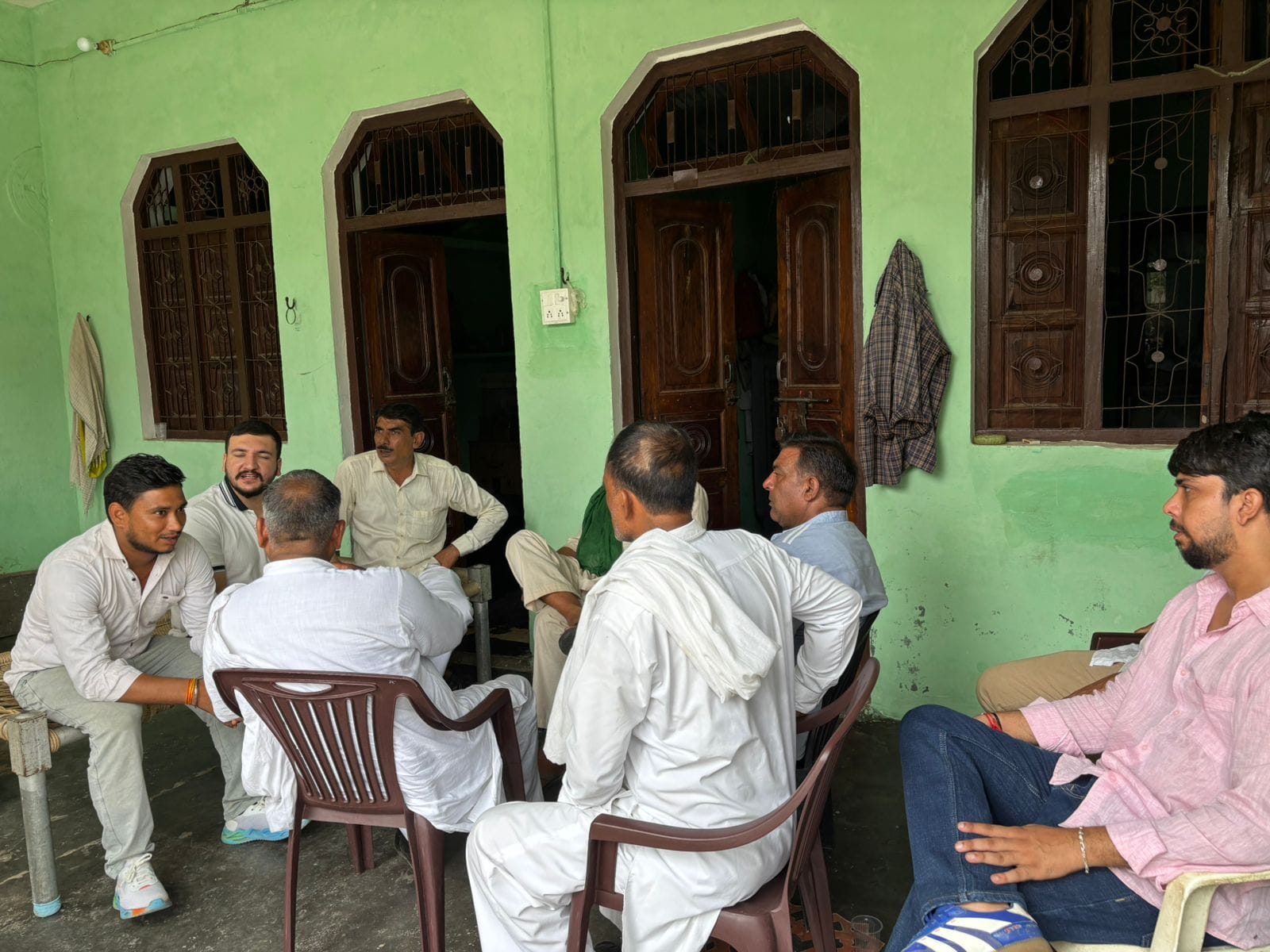 Ankit’s father Satbir Singh surrounded by local residents at the family home in Shamli | Samridhi Tewari/ThePrint
