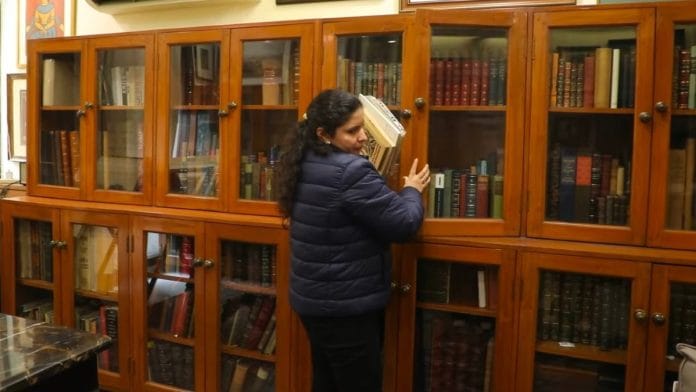 Rashi Jain Dugar, one of the founders of Memoirs of India, arranges the books inside the store at South Extension, New Delhi | Anisha Nehra, ThePrint