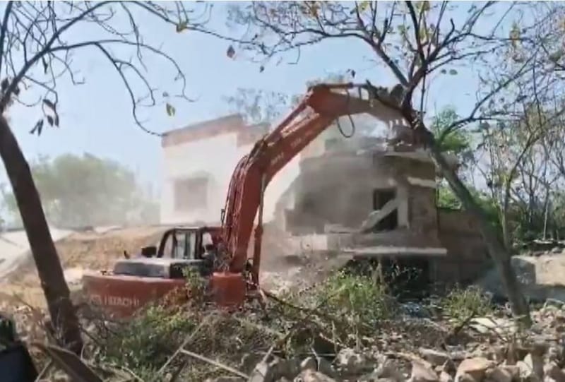 सैनिक फार्म में अप्रैल 2026 में एक फार्महाउस गिराया जा रहा है | एक्स स्क्रीनग्रैब/@PTI_News