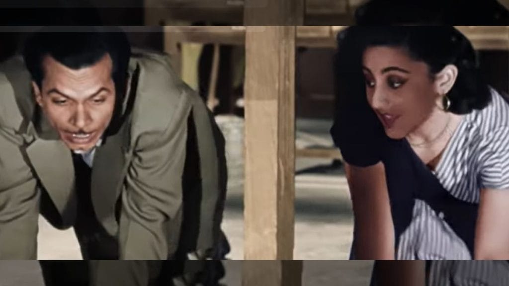 Johnny Walker and Yasmin duck under desks together, dodging the watchful eyes of their co-workers as they convey their feelings through the song “Jaane Kahan Mera Jigar Gaya Ji”, sung by Mohammad Rafi and Geeta Dutt | Screengrab from video