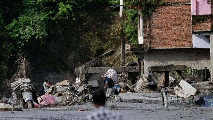 Nepal flash floods LIVE UPDATES: A man carrying his belongings moves through debris following floods in Trishuli in Nuwakot district, Nepal on 27 August, 2026 | Navesh Chitrakar/Reuters