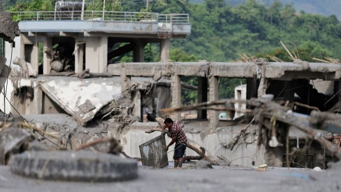 A man salvages his belongings from mud following devastating floods, in Trishuli in Nuwakot district, Nepal, August 27, 2026 | REUTERS/Navesh Chitrakar