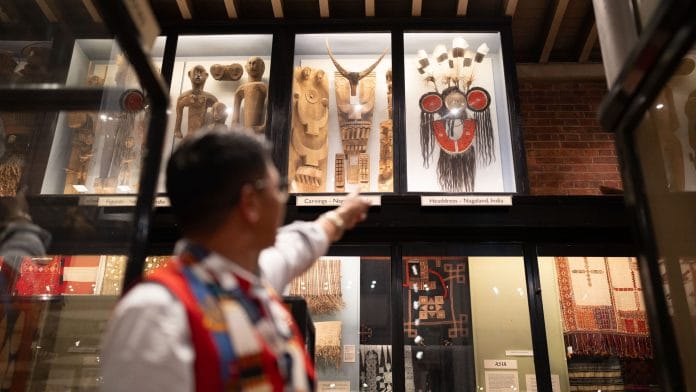 A member of the Naga delegation points toward an indigenous Naga headdress | Picture credit: Pitt Rivers Museum