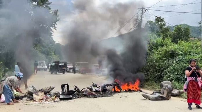 A vehicle set on fire on a road in Taphou area amid reports of violence, in Senapati. | ANI