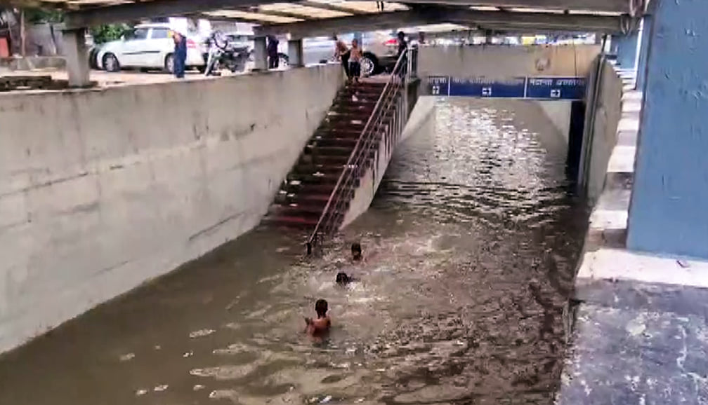 Children swim in a waterlogged underpass, following continuous rainfall, at Gurugram's Rajiv Chowk on 25 August 2026 | ANI