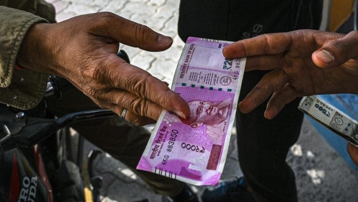 A man pays for petrol in Rs.2000/- currency note at a petrol pump in New Delhi, India. | Prakash Singh/Bloomberg