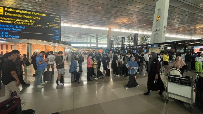 Passengers line up at an information counter at Soekarno-Hatta International Airport near Jakarta after volcanic ash from Mount Anak Krakatau disrupted flights on Sept. 6. | Rieka Rahadiana/Bloomberg