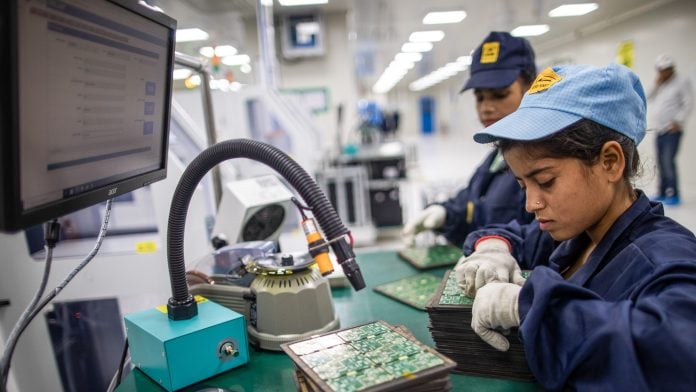 Workers assemble circuit boards at a factory in Noida, India. Photographer: Prashanth Vishwanathan/Bloomberg