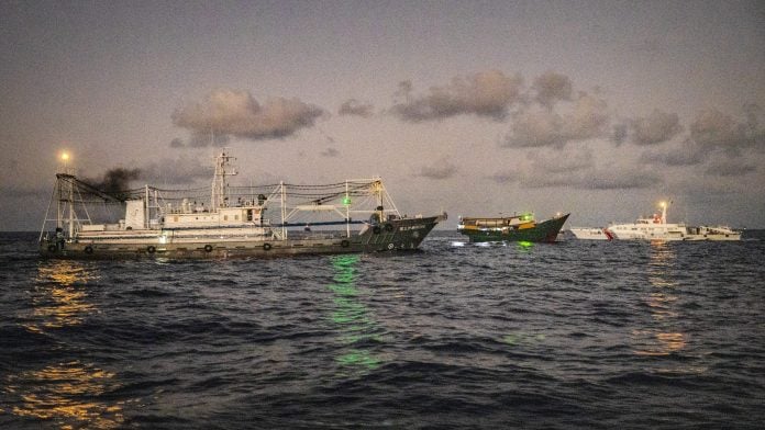 A Philippine Navy chartered vessel, conducting a routine resupply mission to troops stationed at Second Thomas Shoal, is flanked by a Chinese Coast Guard and militia ship in the South China Sea on March 5, 2024.