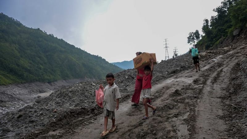 त्रिशूली 3-A टनल रसुवा और नुवाकोट जिलों के बीच स्थित है. सड़कें नहीं होने और पहुंच बहुत सीमित होने के कारण बाढ़ से प्रभावित गांव वालों को राहत के पैकेट लेने के लिए पथरीले रास्तों पर पैदल चलना पड़ता है | फोटो: सूरज सिंह बिष्ट/दिप्रिंट