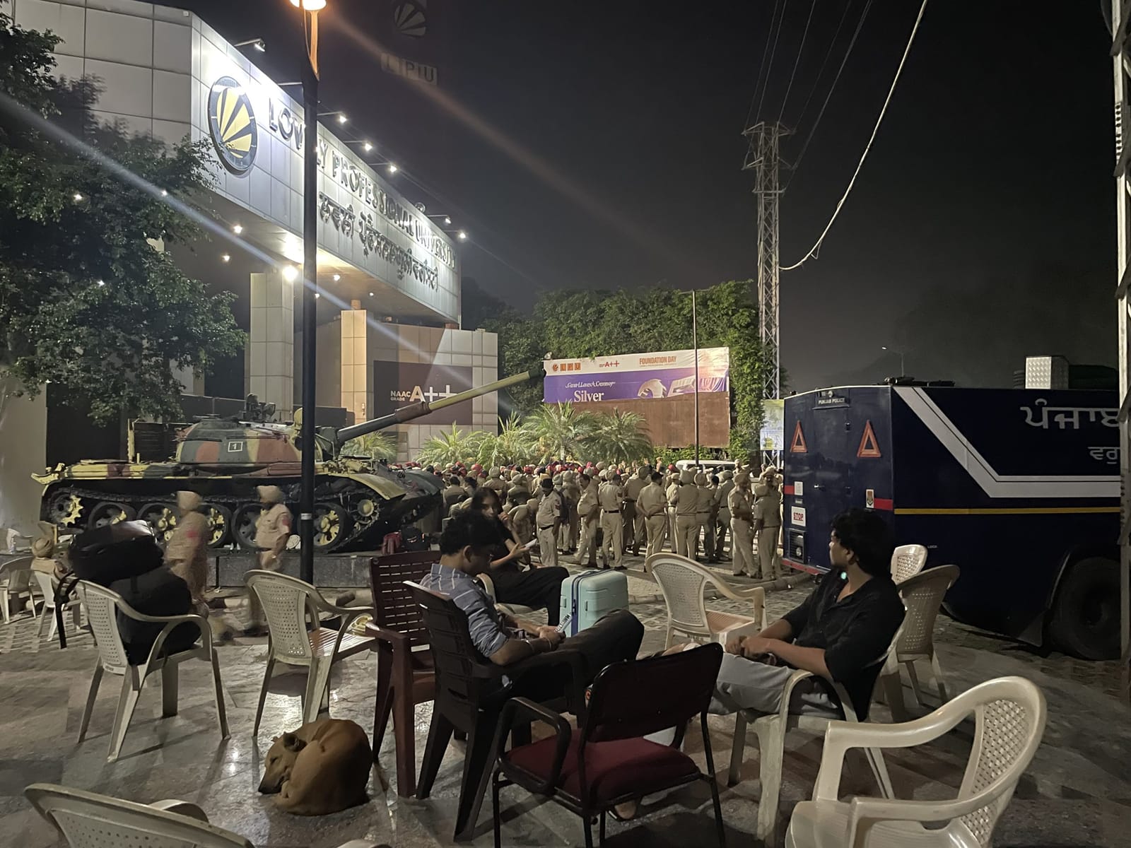 डिस्प्ले बोर्ड पर LPU का एक फटा हुआ पोस्टर लगा है, जबकि पुलिसकर्मी कैंपस के गेटों की सुरक्षा कर रहे हैं | फोटो: अलीशा दत्ता/दिप्रिंट