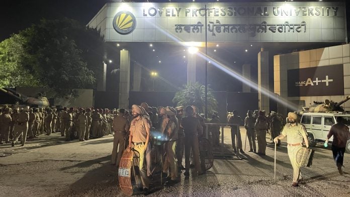 Police personnel holding riot shields stand vigilant outside the Lovely Professional University's gates | Alisha Dutta | ThePrint