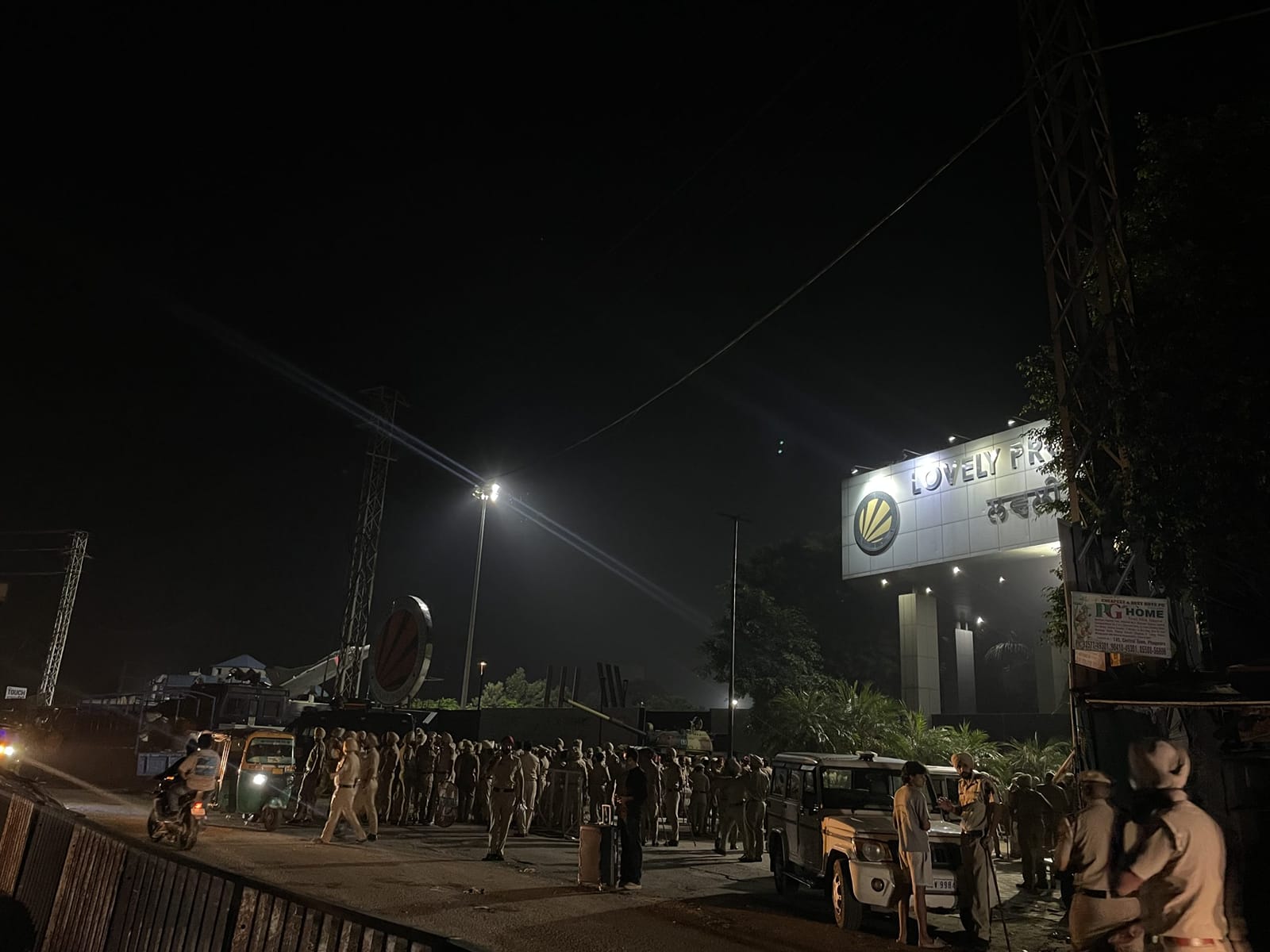 LPU के गेट के बाहर एक छात्र सूटकेस लेकर घर जाने का इंतज़ार कर रहा है. वहां बड़ी संख्या में पुलिसकर्मी तैनात हैं | फोटो: अलीशा दत्ता/दिप्रिंट