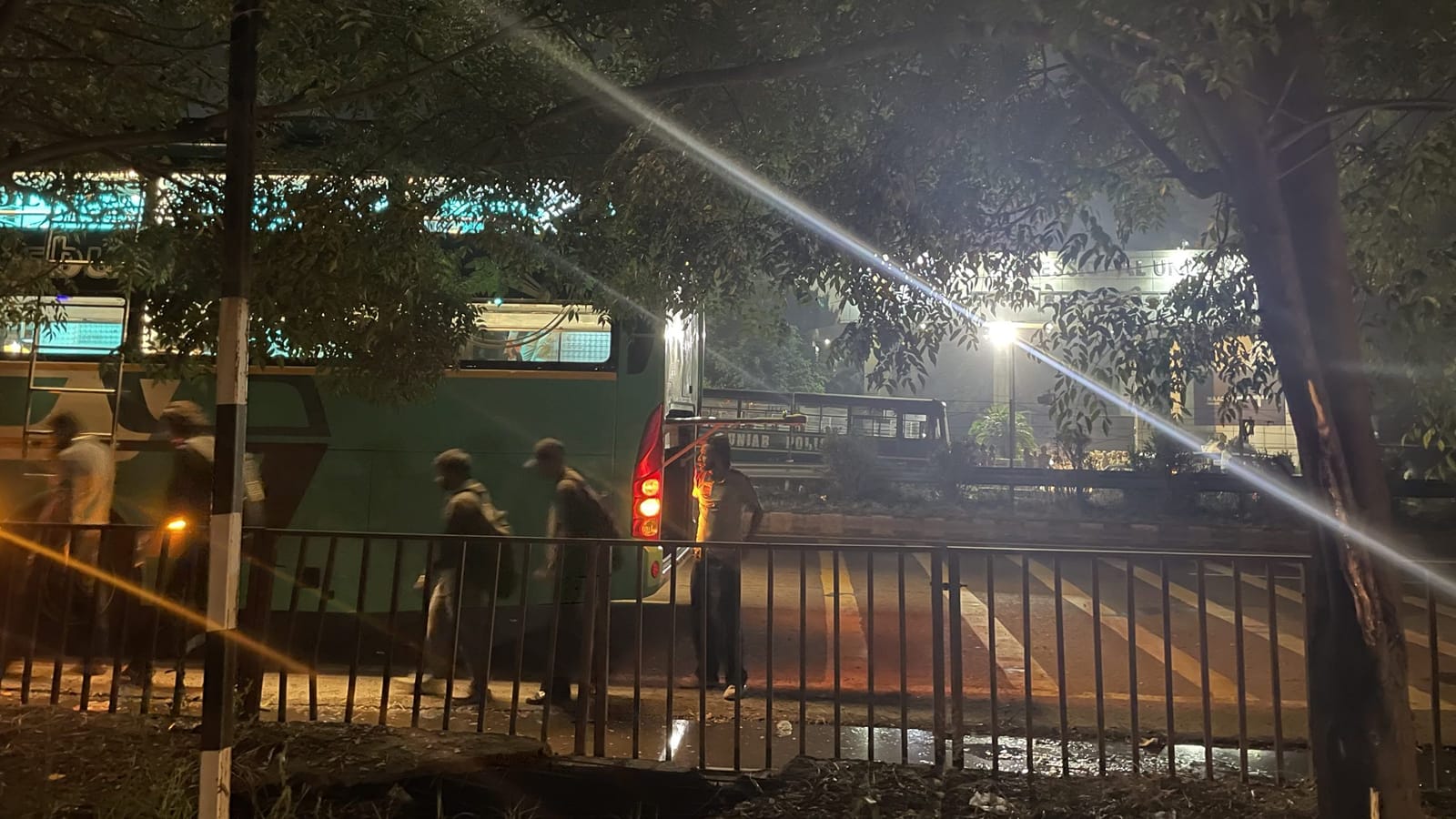LPU के छात्र घर जाने के लिए बसों में बैठते हुए. सड़क के दूसरी ओर पुलिस की एक गाड़ी तैनात है | फोटो: अलीशा दत्ता/दिप्रिंट