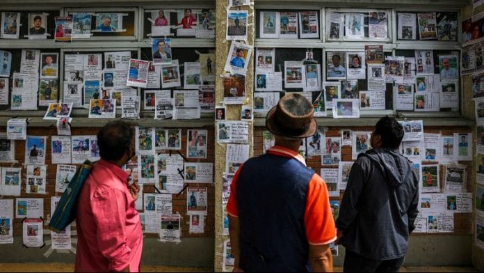 People look at photographs of missing people on a wall outside Tribhuvan University Teaching Hospital following the deadly flash floods and mudslide, reacts outside Tribhuvan University Teaching Hospital, in Kathmandu, Nepal, September 2. REUTERS/Athit Perawongmetha