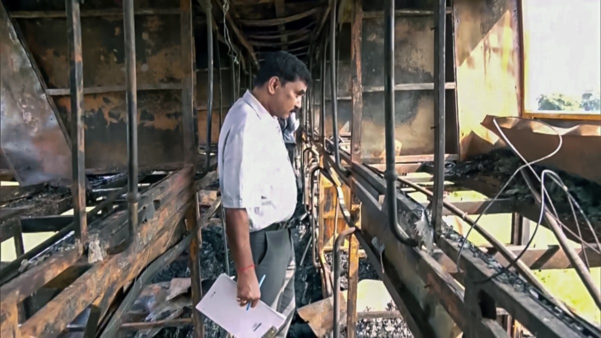 An official inspecting charred sleeper bus in Greater Noida on 25 September, 2026 | ANI
