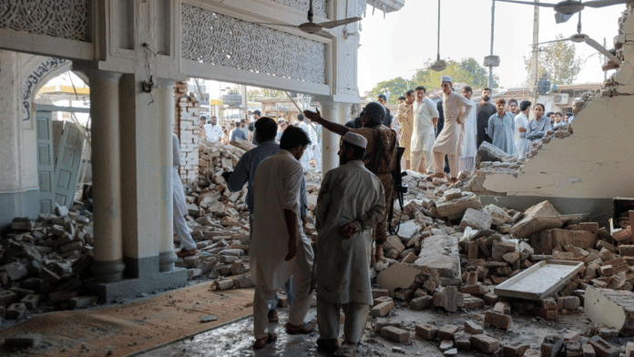 People gather at a damaged mosque following a suicide attack at a police facility in Kohat, Pakistan | Reuters/Stringer