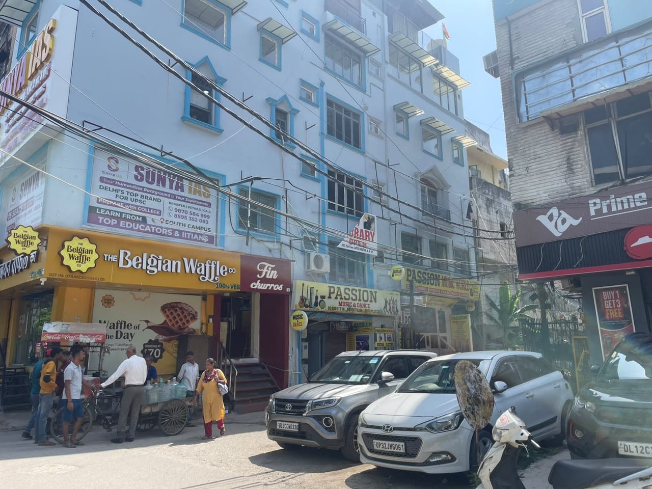 सत्या निकेतन के 299 घरों में से कई के ग्राउंड फ्लोर पर चमक-दमक वाले खाने के ठेले, चाय की दुकान या ई-सर्विस की दुकान है | फोटो: अलीशा दत्ता/दिप्रिंट