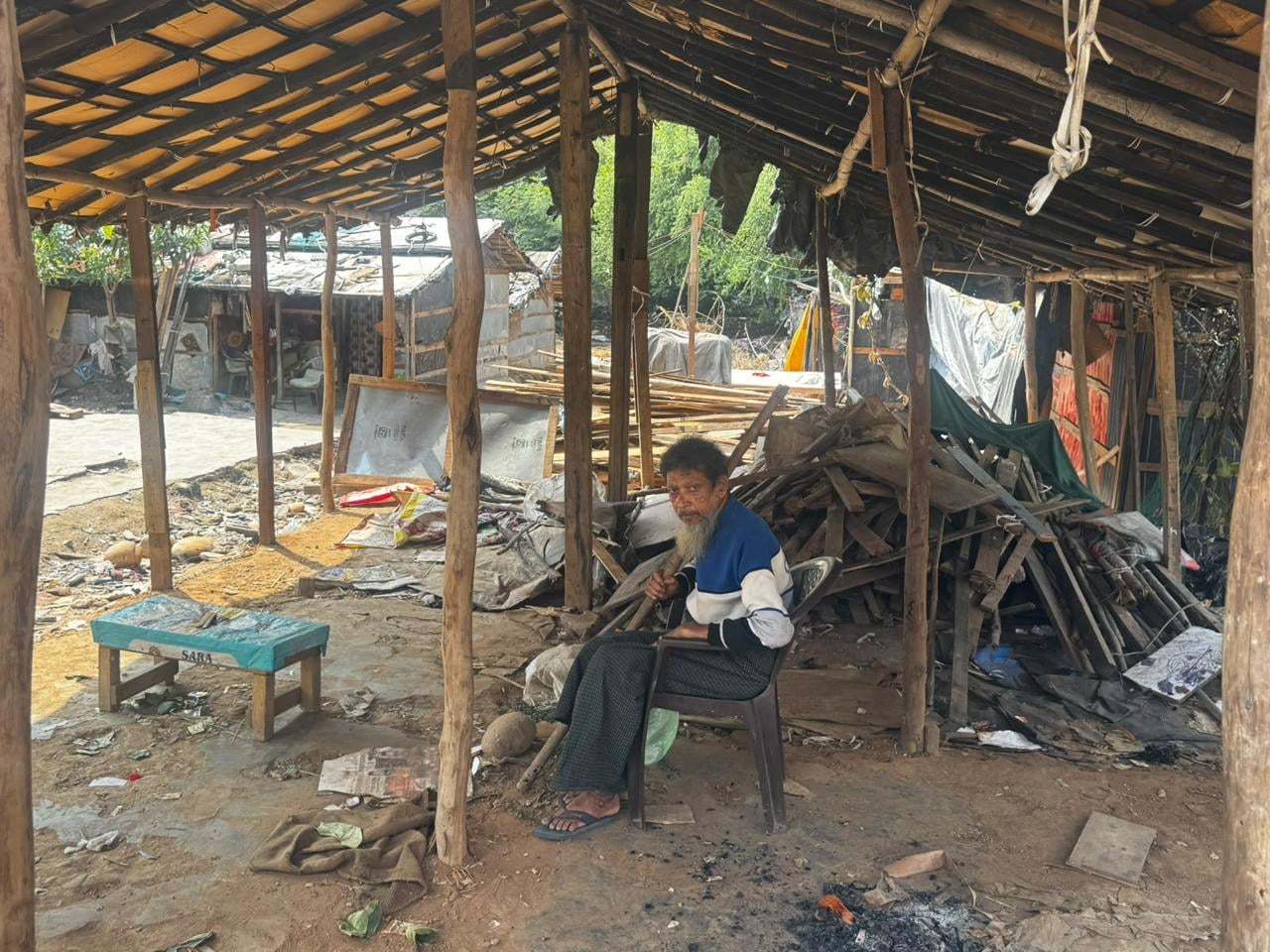 An elderly Rohingya refugee sits beneath a shelter at a settlement in Jammu. | Photo: Sagrika Kissu | ThePrint