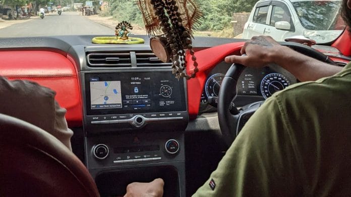 Back view of a driver and passenger in a car in India during the day