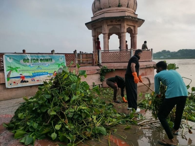 प्रतीक भारद्वाज और गो फॉर गोमती के स्वयंसेवक कुड़िया घाट पर गोमती से जलकुंभी और कचरा निकालते हुए | फोटो: हर्ष तिवारी/दिप्रिंट