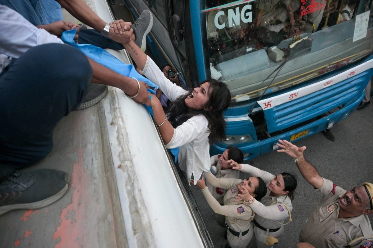 Congress supporters help a girl climb onto the top of a bus amid police detention | Suraj Singh Bisht | ThePrint