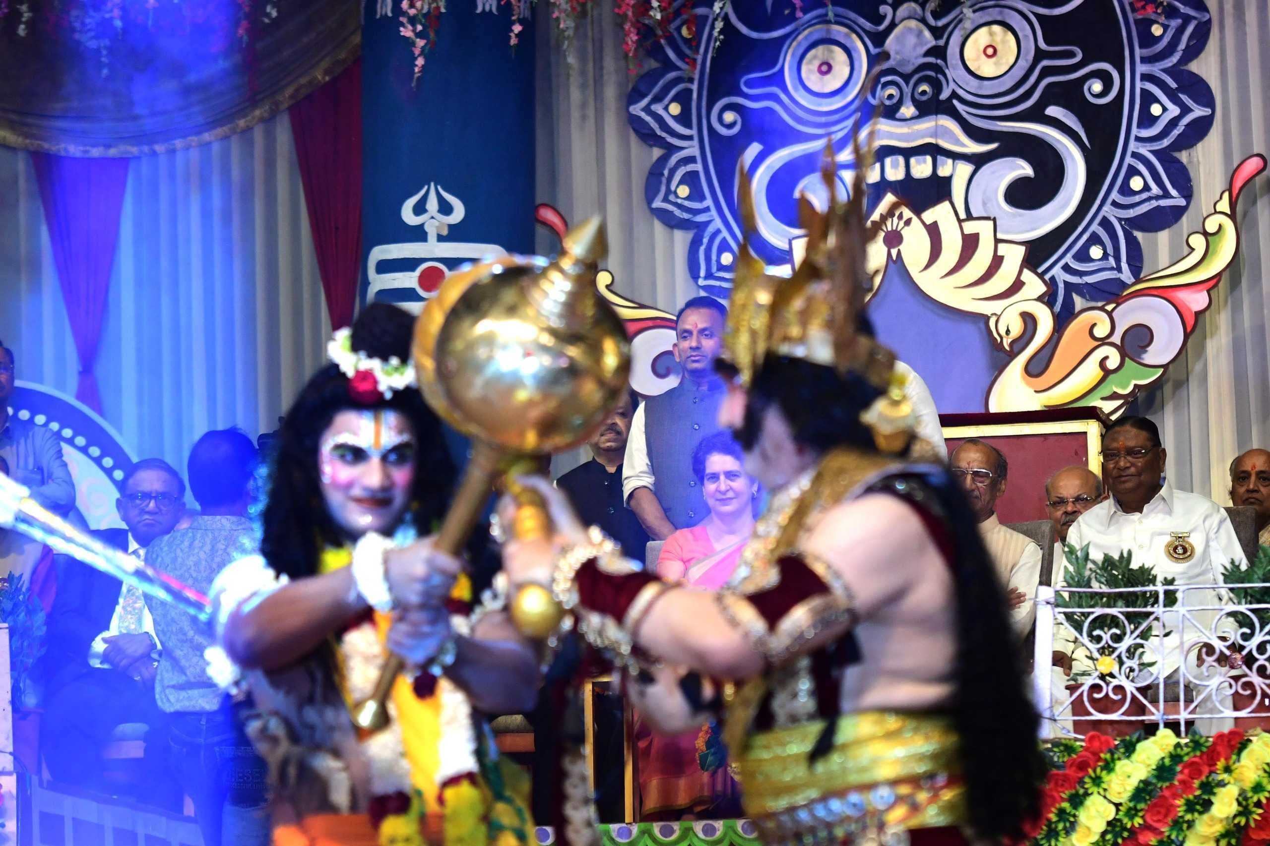 Congress leader Priyanka Gandhi Vadra (seated in the background between the two characters on the stage) during Dussehra festival celebrations of Nav Shri Dharmik Leela Committee, at Red Fort in New Delhi | ThePrint Photos