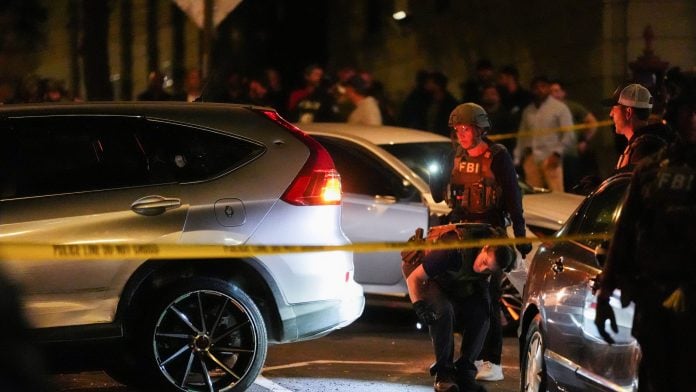 Federal agents investigate a vehicle near the scene of a shooting reportedly involving US Immigration and Customs Enforcement (ICE) officers in the Bronx borough of New York City, US, October 8, 2026. REUTERS/David Dee Delgado