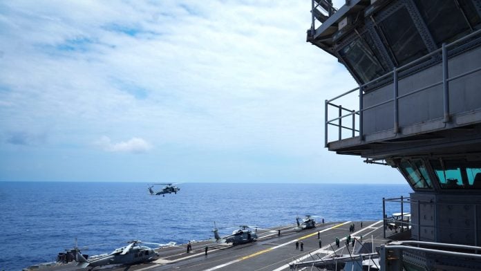 A military helicopter approaches for landing on the aircraft carrier USS Theodore Roosevelt in the Pacific Ocean near Hawaii in July. Photographer: Michelle Bir/AFP/Getty Images | Bloomberg