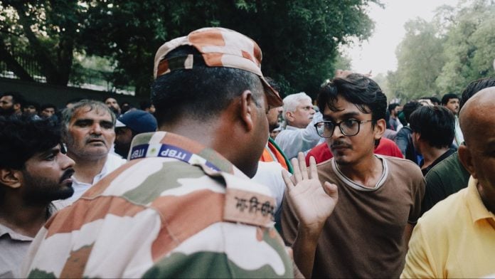 A student gestures towards a security personnel during the protest march at Bhagwan Das Road in Delhi on Monday | Photo: Manisha Mondal | ThePrint