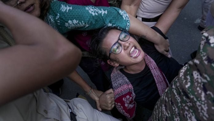 All India Students' Association (AISA) National President Neha Bora being detained by police personnel during a protest against Chief Election Commissioner (CEC) Gyanesh Kumar, demanding his resignation over the alleged irregularities in the Special Intensive Revision (SIR) of electoral rolls and mass deletion of voters, at Jantar Mantar, in New Delhi, Saturday, Oct. 3, 2026. (PTI Photo/Karma Bhutia)(PTI10_03_2026_000348B)