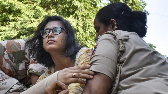 AISA national president Neha Bora climbs a police barricade near Ashoka Road as student activists attempt to march towards Jantar Mantar, demanding the removal of Chief Election Commissioner (CEC) Gyanesh Kumar, in New Delhi, Sunday, Oct. 4, 2026. | PTI Photo/Rushikesh More