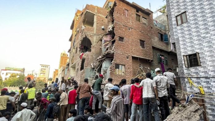 People gather on site after a four-storey building collapsed, with debris burying portions of two to three adjoining houses, in the Seemapuri area, New Delhi, Wednesday, Oct. 7, 2026. | PTI Photo/Arjun Sree Kumar