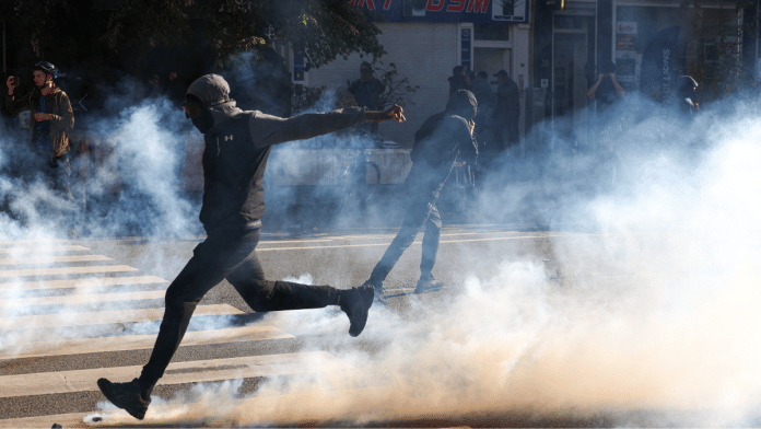 A demonstrator kicks a tear-gas-emitting object during a student protest in Brussels, Belgium on Saturday | Reuters