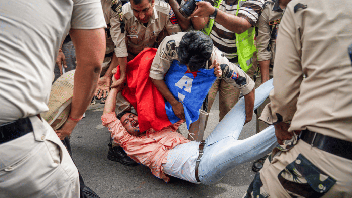 A man being detained during protest against CEC Gyanesh Kumar in New Delhi on Sunday. | ANI