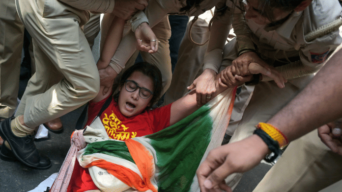 AISA president Neha Bora is detained by police personnel during the protest demanding the resignation of CEC Gyanesh Kumar | Suraj Singh Bisht | ThePrint