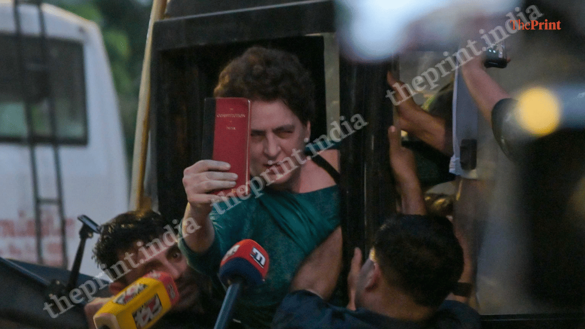 Priyanka Gandhi Vadra holds up a copy of the Constitution after she is detained by Delhi Police | Suraj Singh Bisht | ThePrint