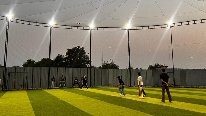 Players take part in a game at a box cricket turf in Gurugram’s rural belt, where compact sports facilities are drawing the city’s after-work crowd | Photo: Manisha Mondal | ThePrint