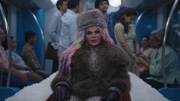 Rakhi Sawant dressed in a winter wardrobe, surrounded by white peaks in the CRED advertisement | Screengrab from YouTube video